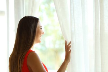 Dalgın kadın yaz aylarında bir pencereden bakıyor