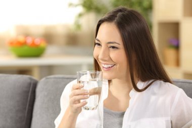 Kadın bardaktan su içiyor.