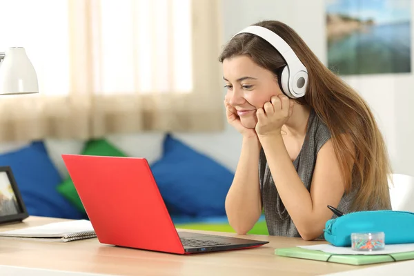 Student lyssnande medieinnehåll på rad i hennes rum — Stockfoto