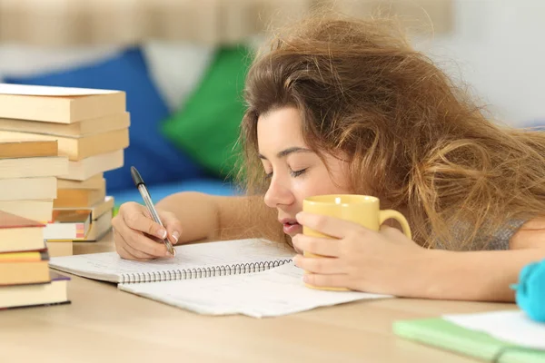 Estudante cansado e sonolento tentando escrever notas — Fotografia de Stock