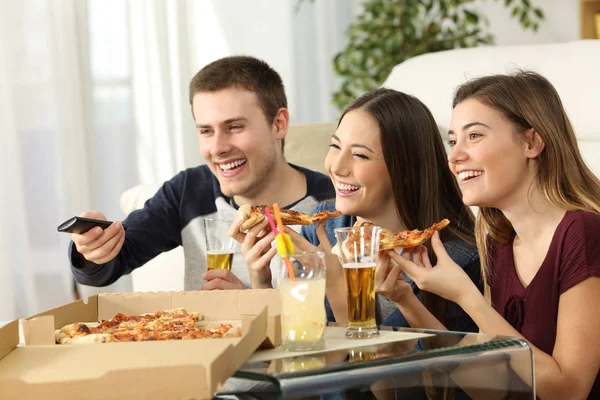 Друзі дивляться телевізор і їдять піцу — стокове фото