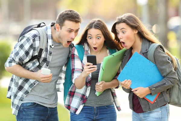 Hayret öğrenciler bir cep telefonu üzerinde içerik denetimi — Stok fotoğraf