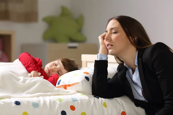 Tired worker mother sleeping beside her daughter — Stock Photo, Image