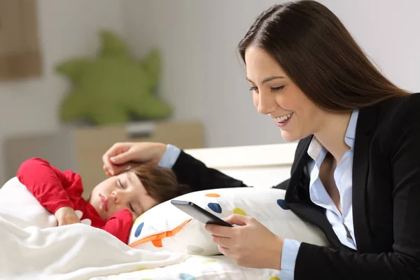 Trabajadora madre trabajando mientras su hijo duerme — Foto de Stock