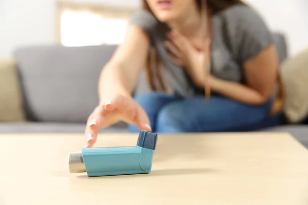 Girl suffering asthma attack reaching inhaler — Stock Photo, Image