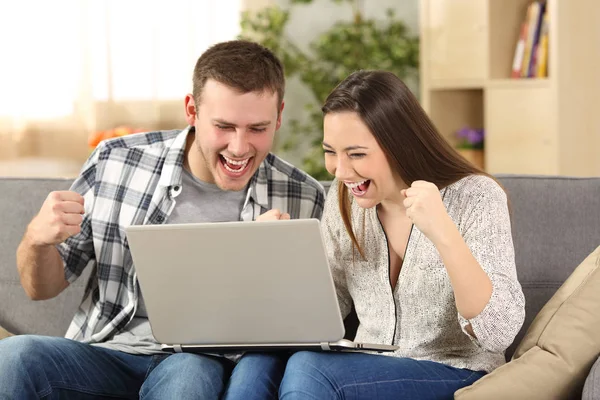 Pareja emocionada leyendo noticias en línea —  Fotos de Stock