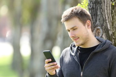 Genç çocuk bir akıllı telefon açık havada kullanma