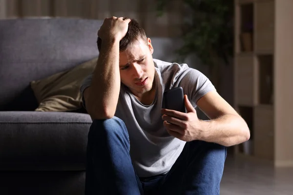 Hombre triste comprobando el teléfono móvil — Foto de Stock