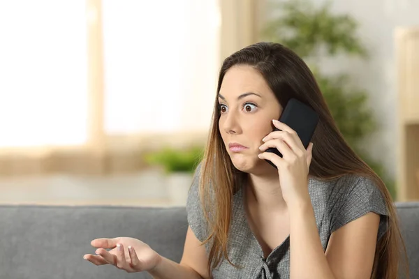 Mujer dudosa escuchando una llamada telefónica — Foto de Stock