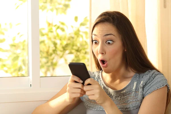 Amazed girl watching content on smart phone — Stock Photo, Image