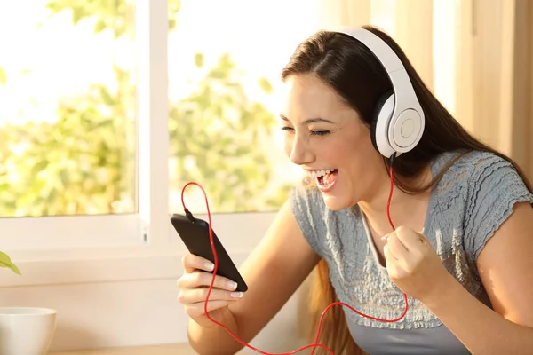 Excited woman listening music with headphones — Stock Photo, Image