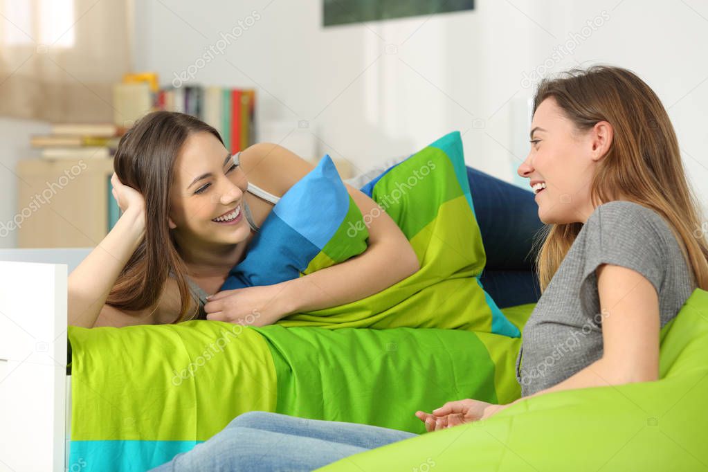 Two teen friends talking in a bedroom
