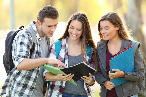 Tre elever lära sig läsa notebook — Stockfoto