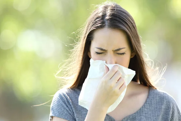 Chica estornudando y soplando en una toallita —  Fotos de Stock
