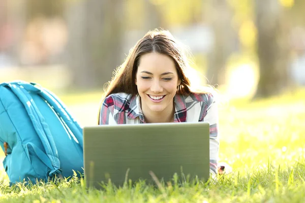 Boldog diák nézi a vonal tartalmat egy laptop — Stock Fotó