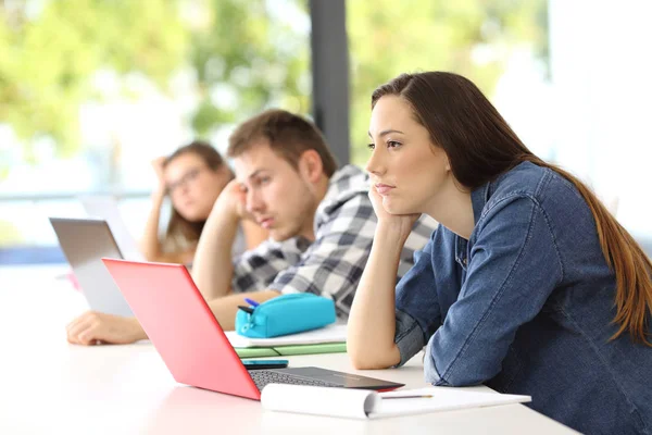 Uttråkad studenter lyssnar lektion i ett klassrum — Stockfoto