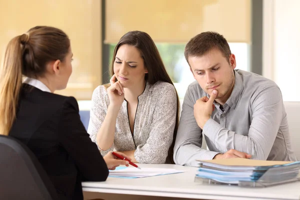 Office worker attending to a suspicious couple — Stock Photo, Image
