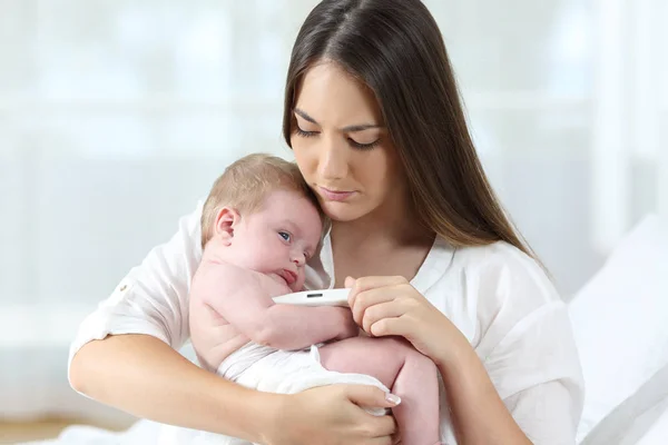 Mère utilisant un thermomètre avec son bébé — Photo