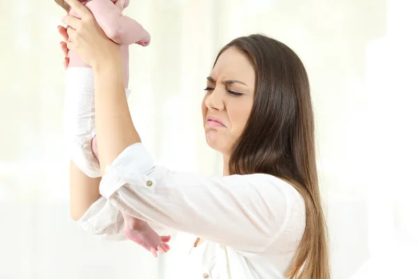 Mãe verificando sua defecação do bebê — Fotografia de Stock