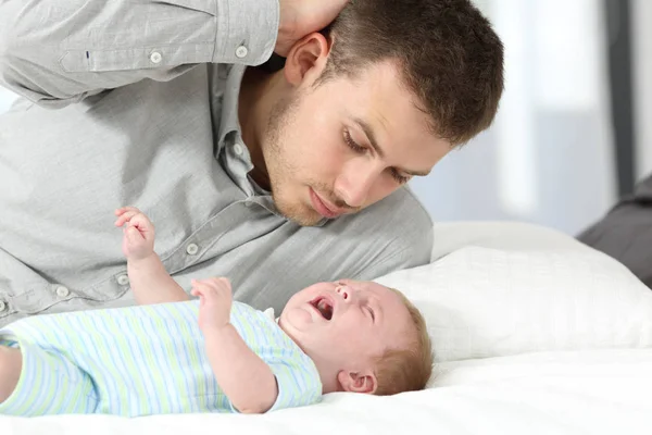 Pai confuso e seu filho bebê chorando — Fotografia de Stock