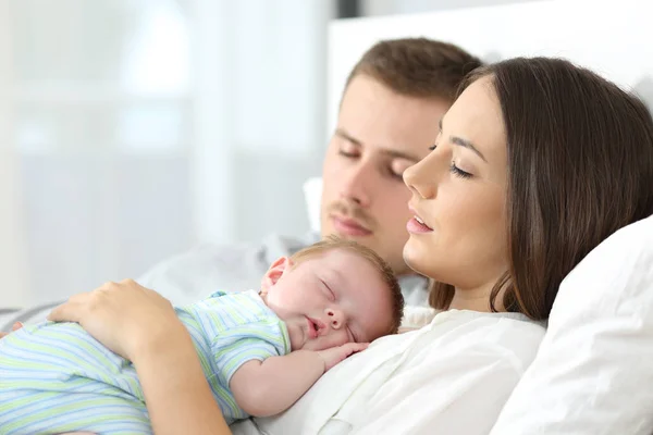 Уставшие родители спят со своим ребенком — стоковое фото