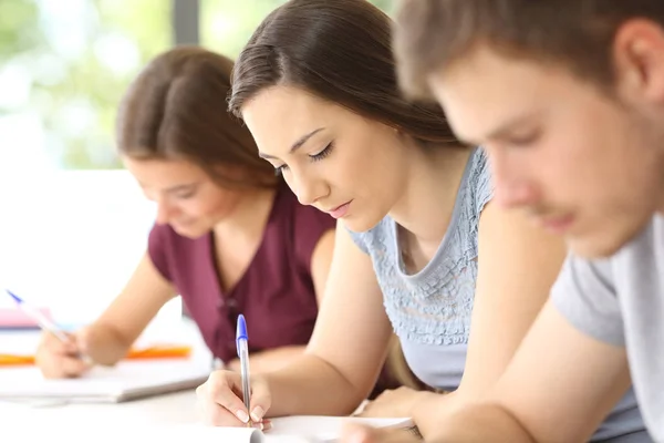 Close up of serious students taking notes — Stock Photo, Image