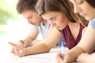 Student reading a cheating sheet during an exam clipart