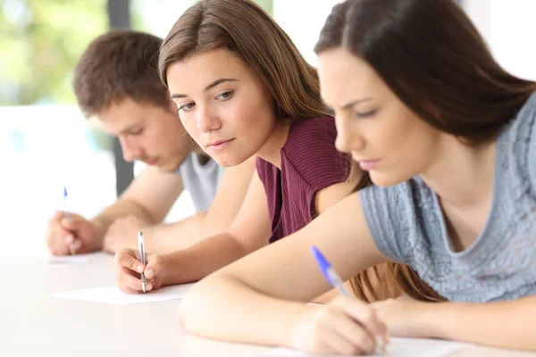 Student trying to copy an exam of a classmate Stock Image