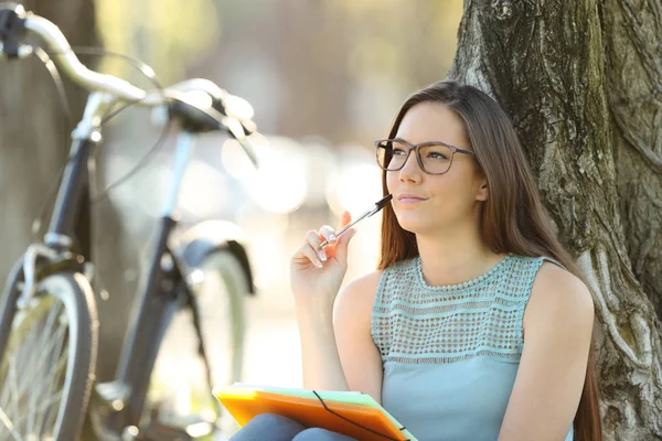 Student denkt im Park sitzend — Stockfoto