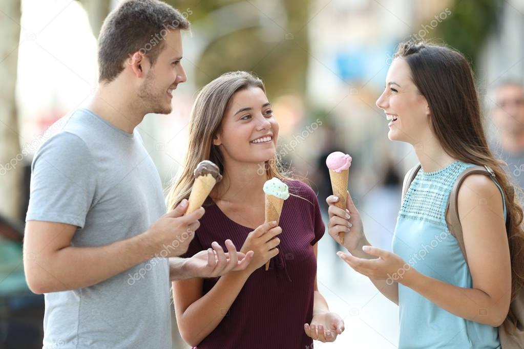 Friends talking and eating ice creams in the street