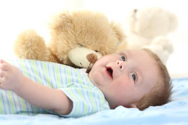 Mutlu bebek ve oyuncak ayı bir yatakta