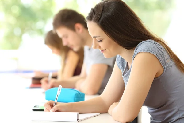 Koncentrerad student anteckningar i ett klassrum — Stockfoto