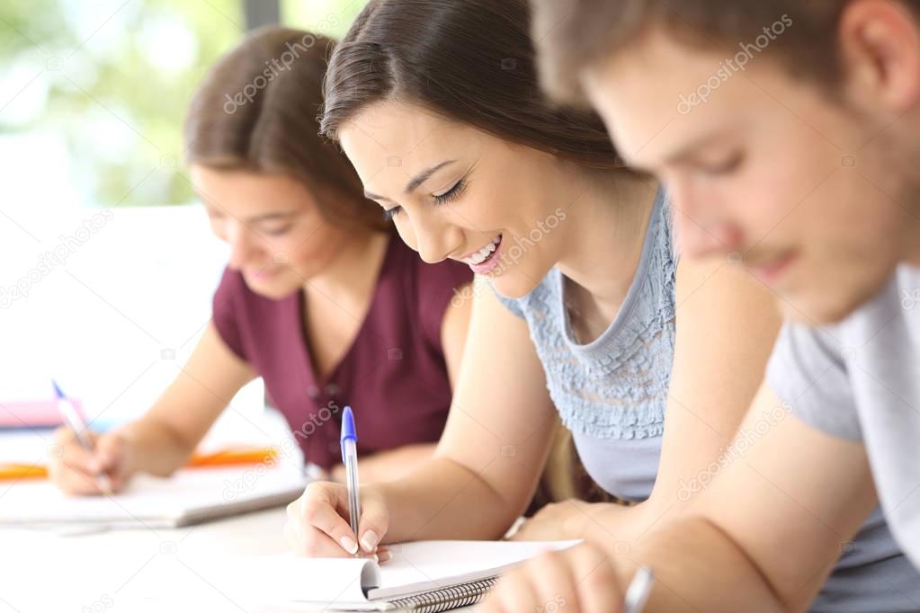 Happy student taking notes in classroom