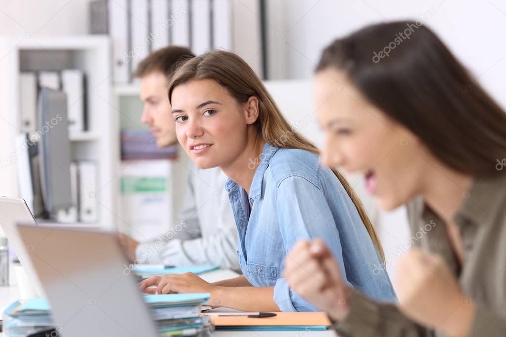 Envious employee looking at a successful colleague