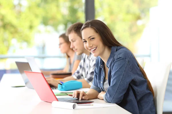 Student met laptop poseren in een klaslokaal — Stockfoto