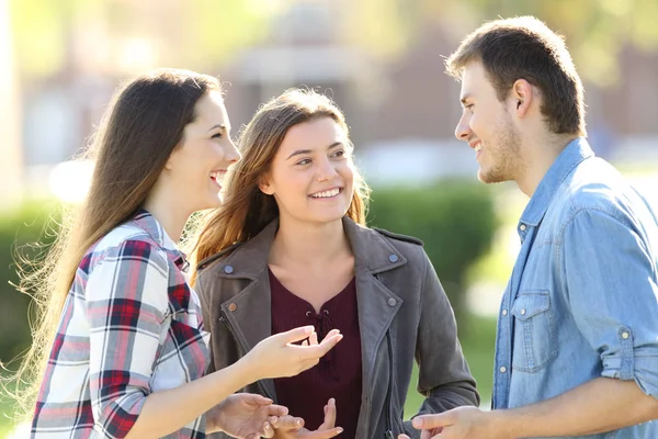 Tre vänner att ha en konversation i gatan — Stockfoto