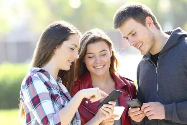 Трое друзей делятся онлайн контентом на улице — стоковое фото