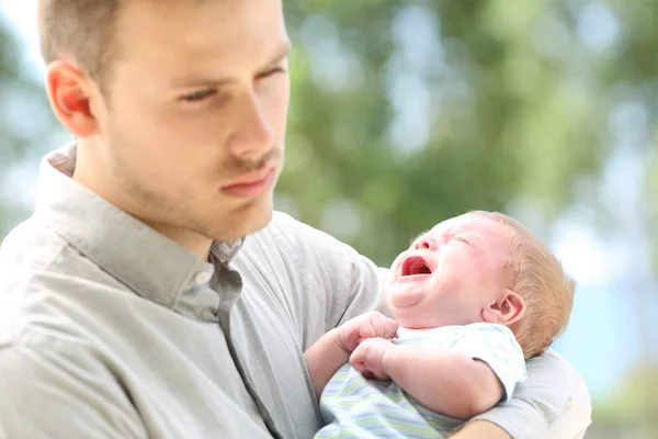 Bebé llorando y aburrido padre — Foto de Stock
