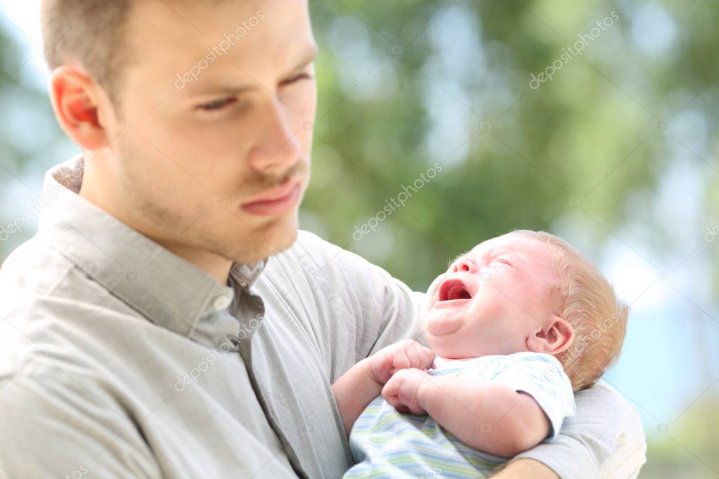 Baby crying and bored father