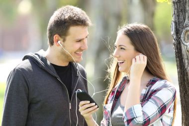 Mutlu çift gençler açık havada müzik paylaşımı