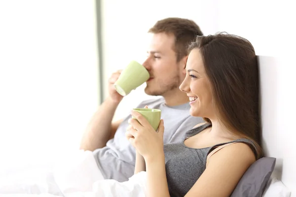 Couple détendu prenant le petit déjeuner sur le lit — Photo