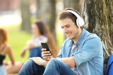 Öğrenci bir parkta kulaklık ile müzik dinleme