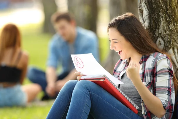 Estudiante emocionado revisando un examen aprobado — Foto de Stock