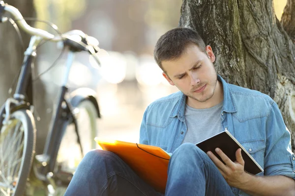 Studente che impara a leggere appunti fuori in un parco — Foto Stock