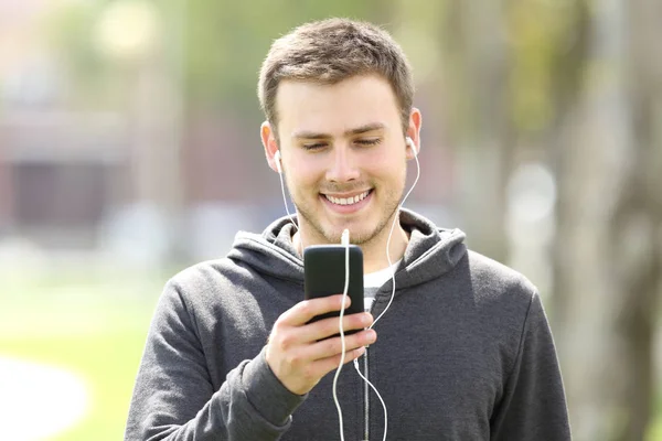 Adolescente niño escuchando música en línea con auriculares —  Fotos de Stock