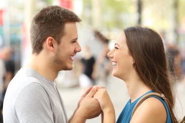 Sokakta el ele tutuşarak aşık Çift