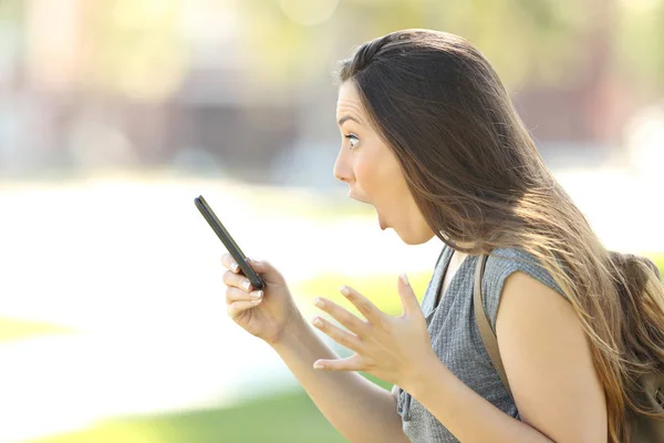 Perfil de uma mulher surpreso usando um telefone — Fotografia de Stock