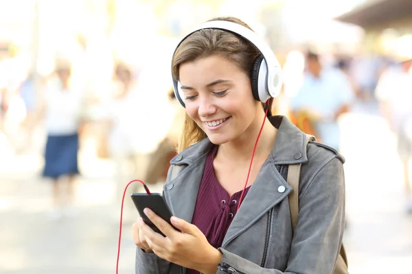 Lycklig tonåring lyssnar musik bär hörlurar — Stockfoto