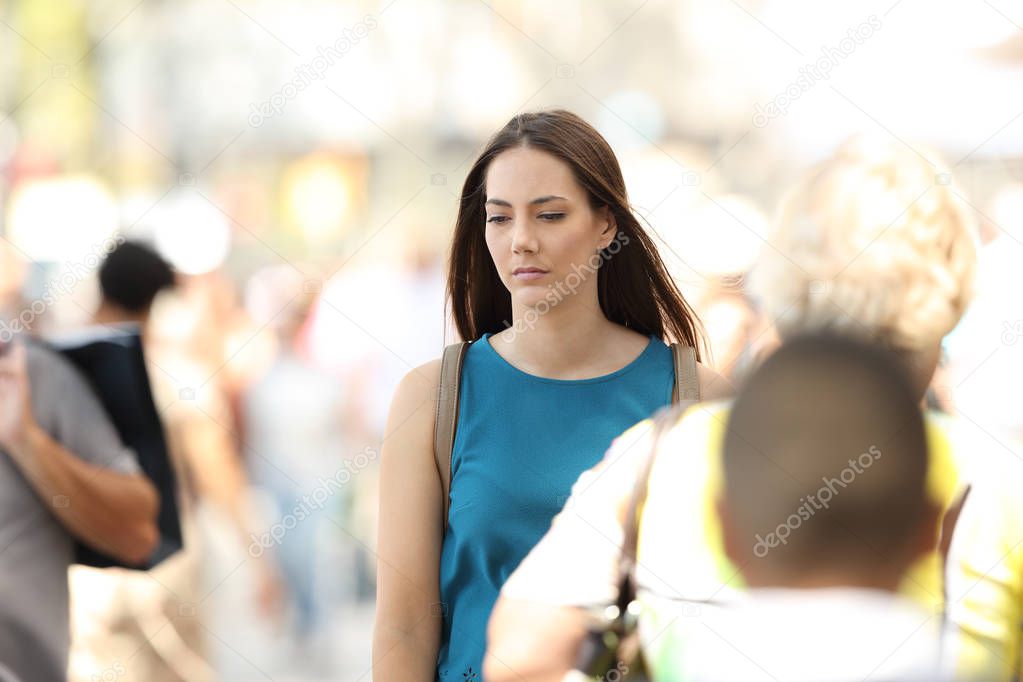 Woman feeling alone walking between people