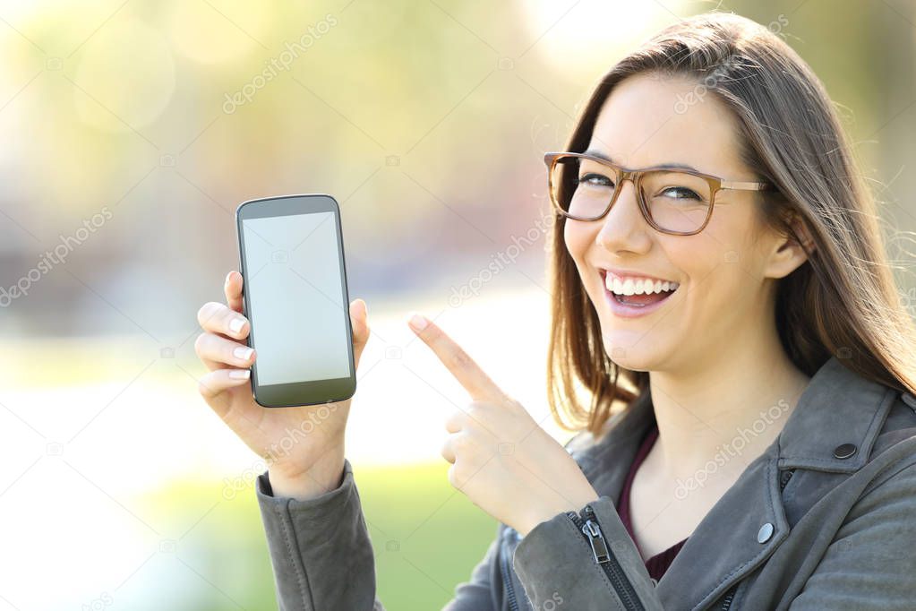 Woman wearing eyeglasses showing a phone screen